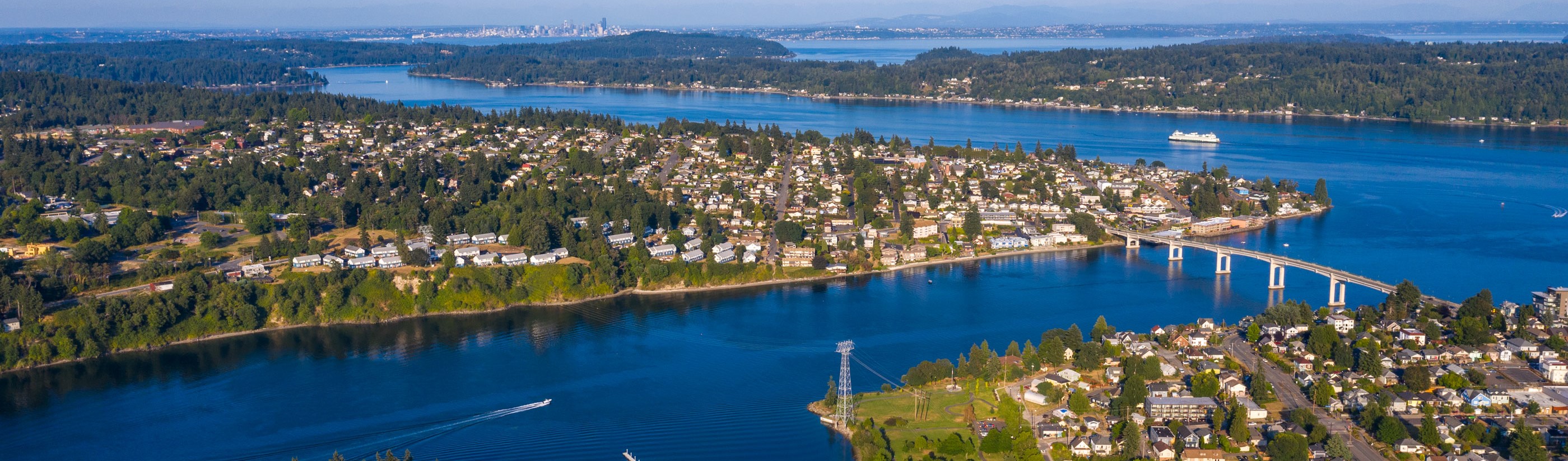 areal of puget sound, homes, bridges, ferry and seatle in the distance