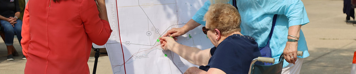 Wheelchair senior placing location markers on map in Wabash County