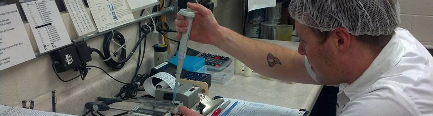 employee pippetting a sample for testing