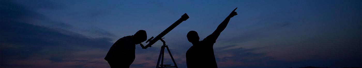 dad and son looking at stars through telescope
