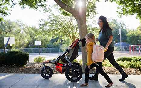 Mother pushing stroller with child