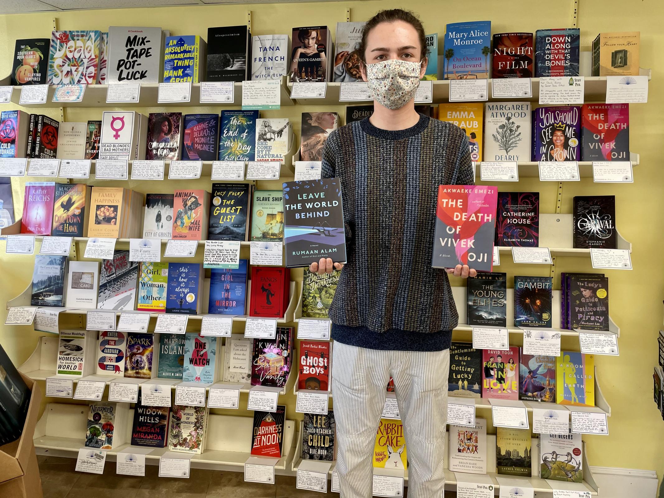 Jack Casey with two favorite books and a wall of staff recommendations