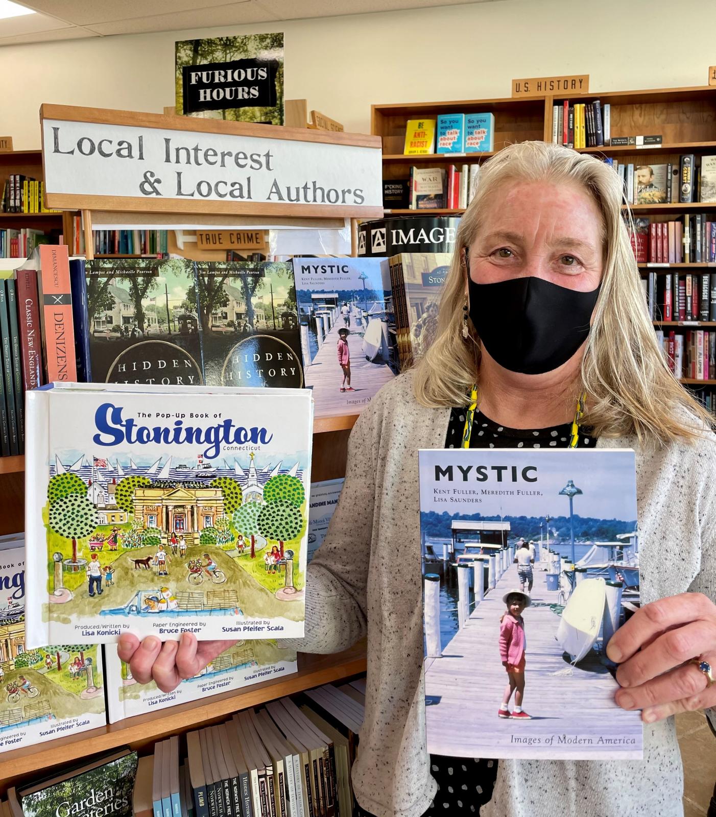 Store owner Annie Philbrick with two local books